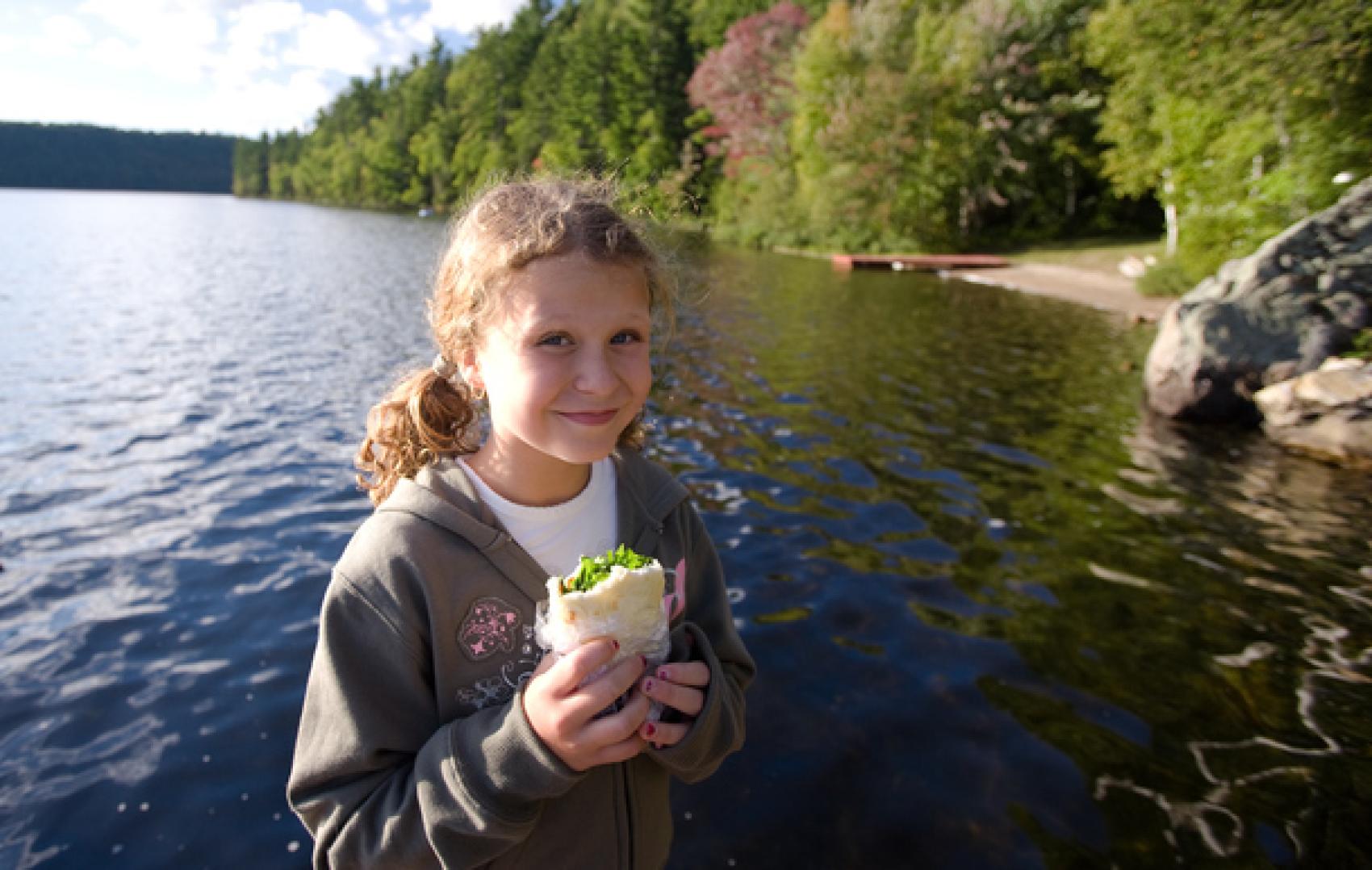 Girl eating by lake