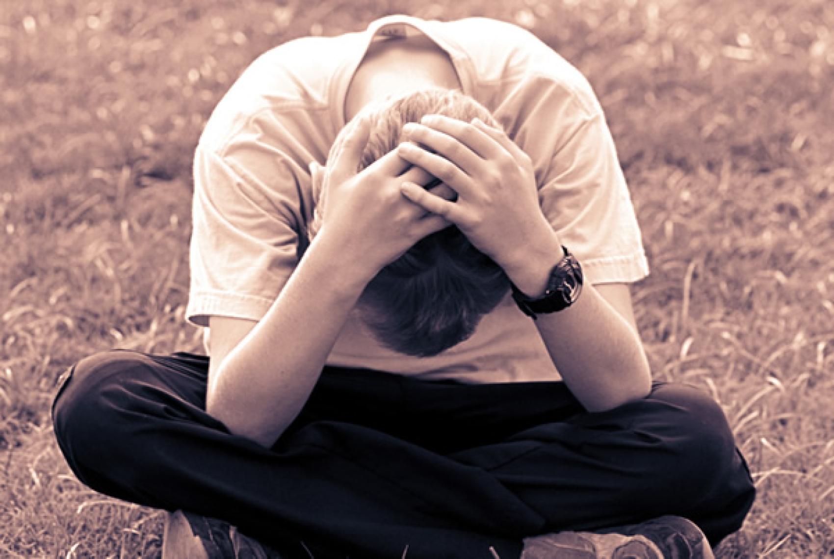 Boy sitting with head down