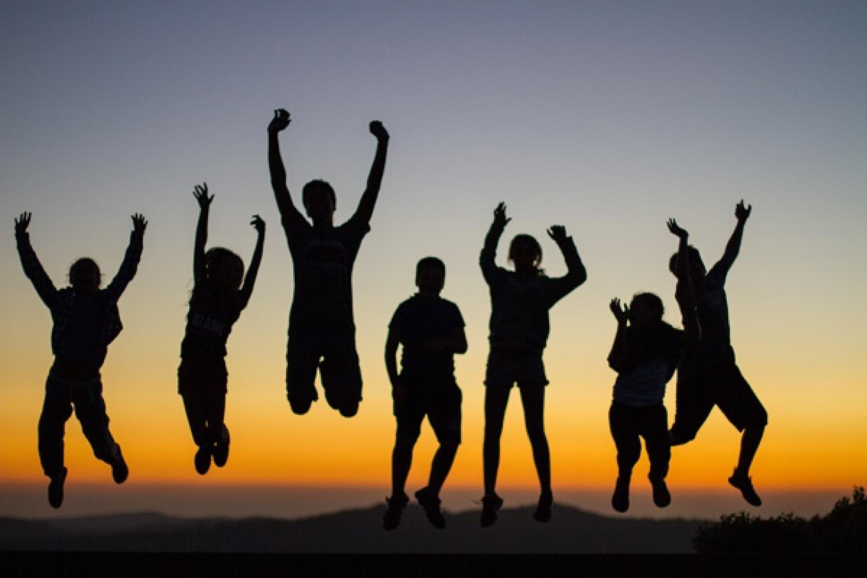 staff jumping at sunset