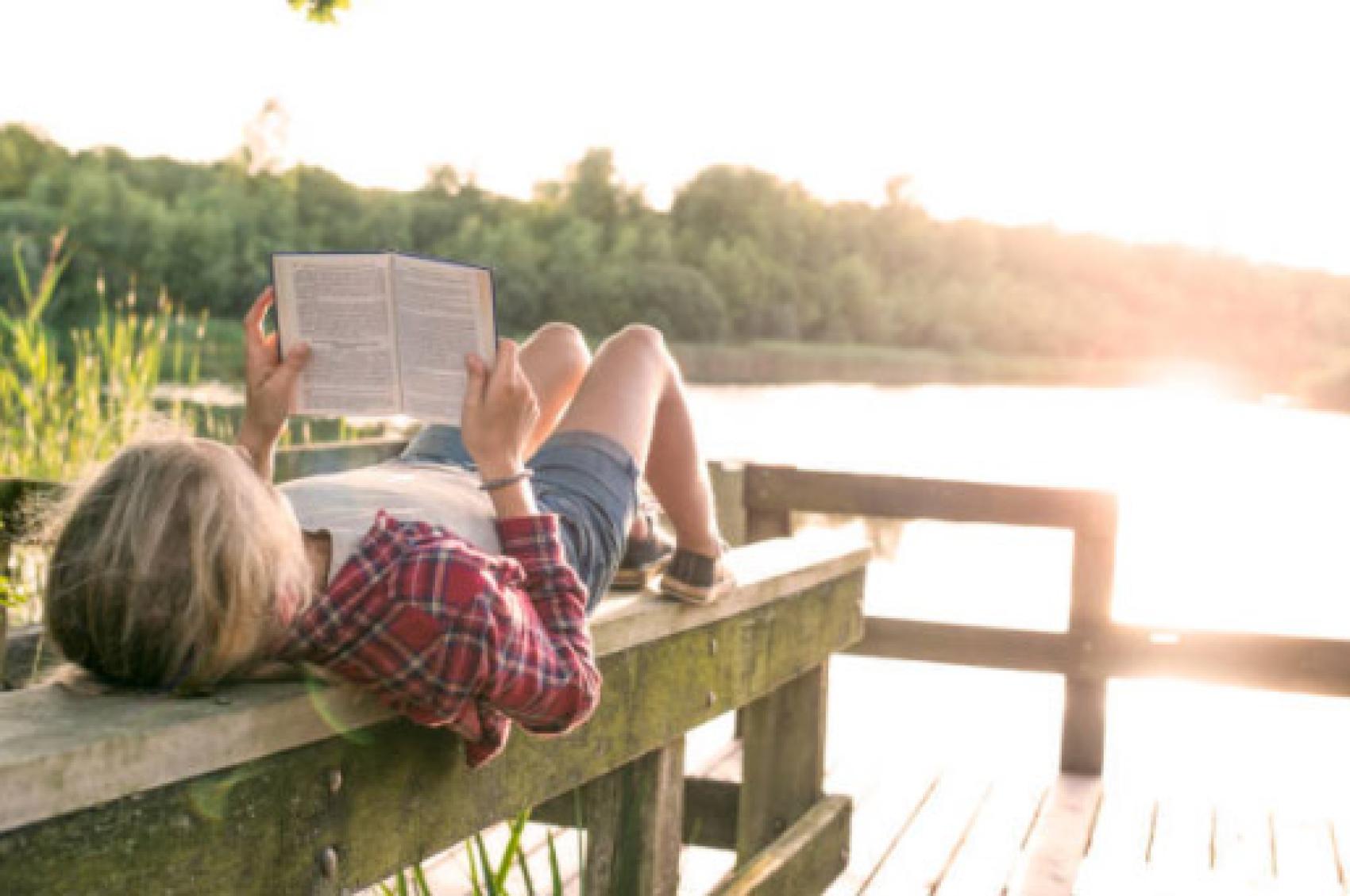 Reading book by lake