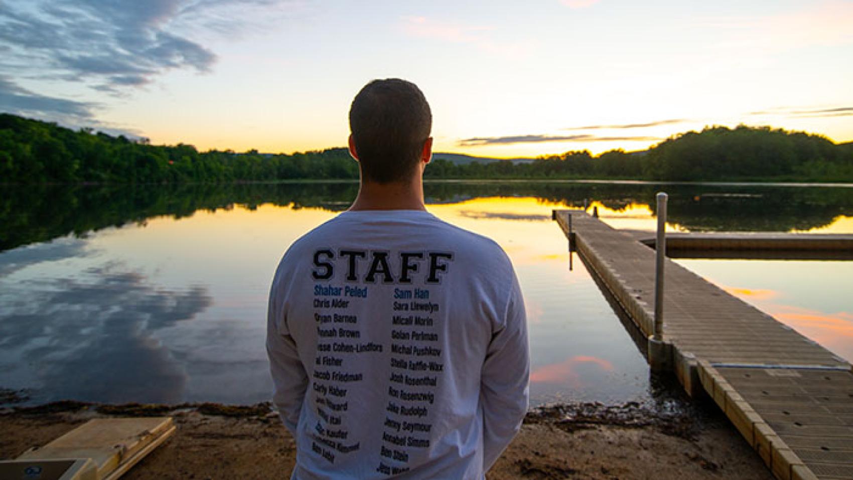 staff member looking over lake at sunrise