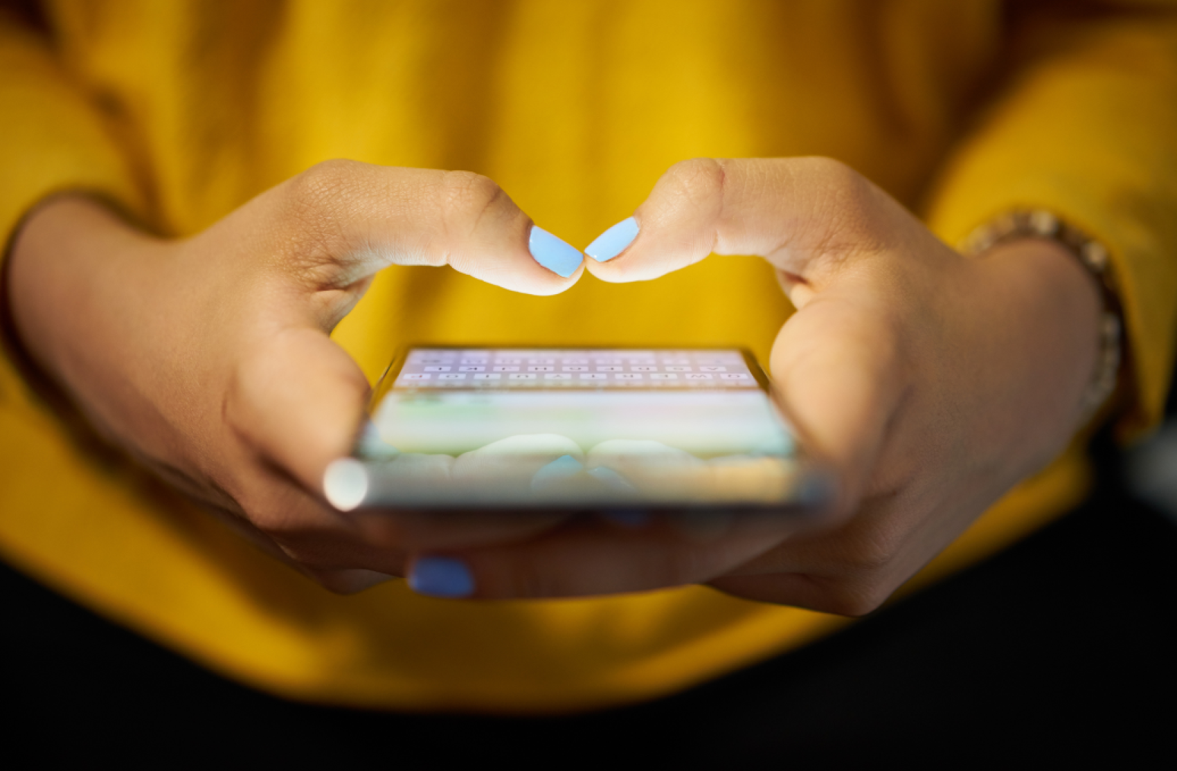 Woman typing phone message at night