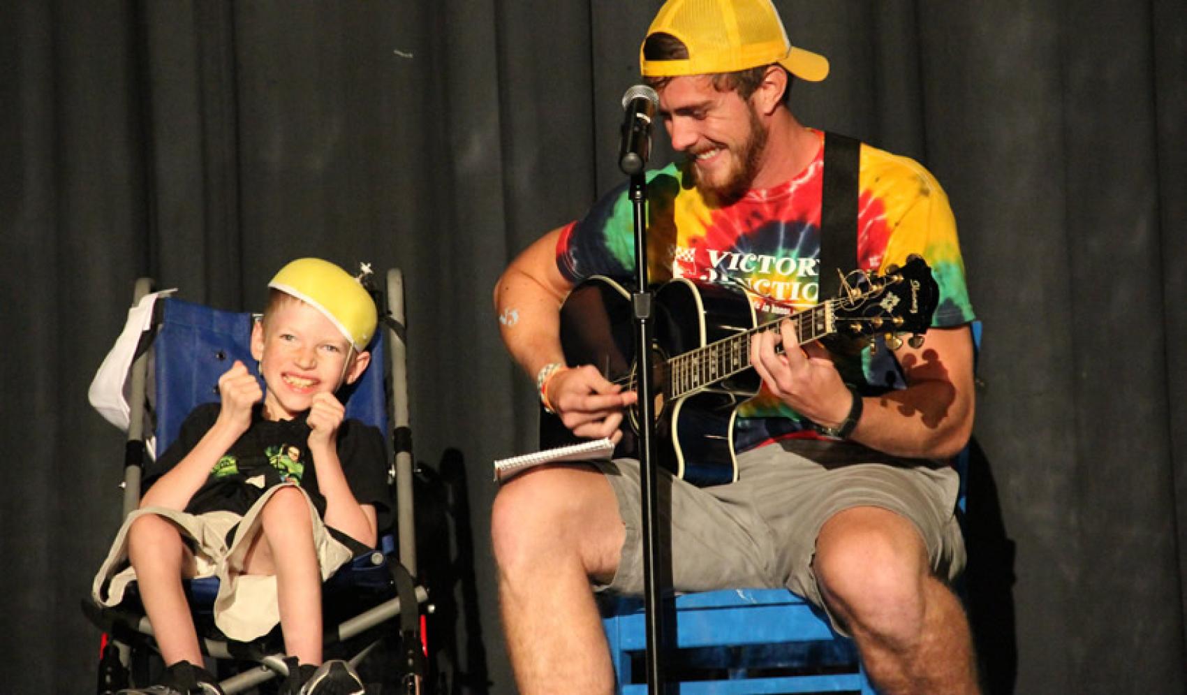 Boy in wheelchair and staff with guitar - Victory Junction, Randleman, NC