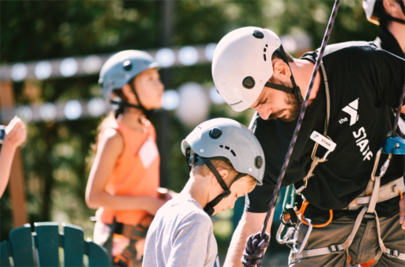 Staff and camper preparing for climbing wall