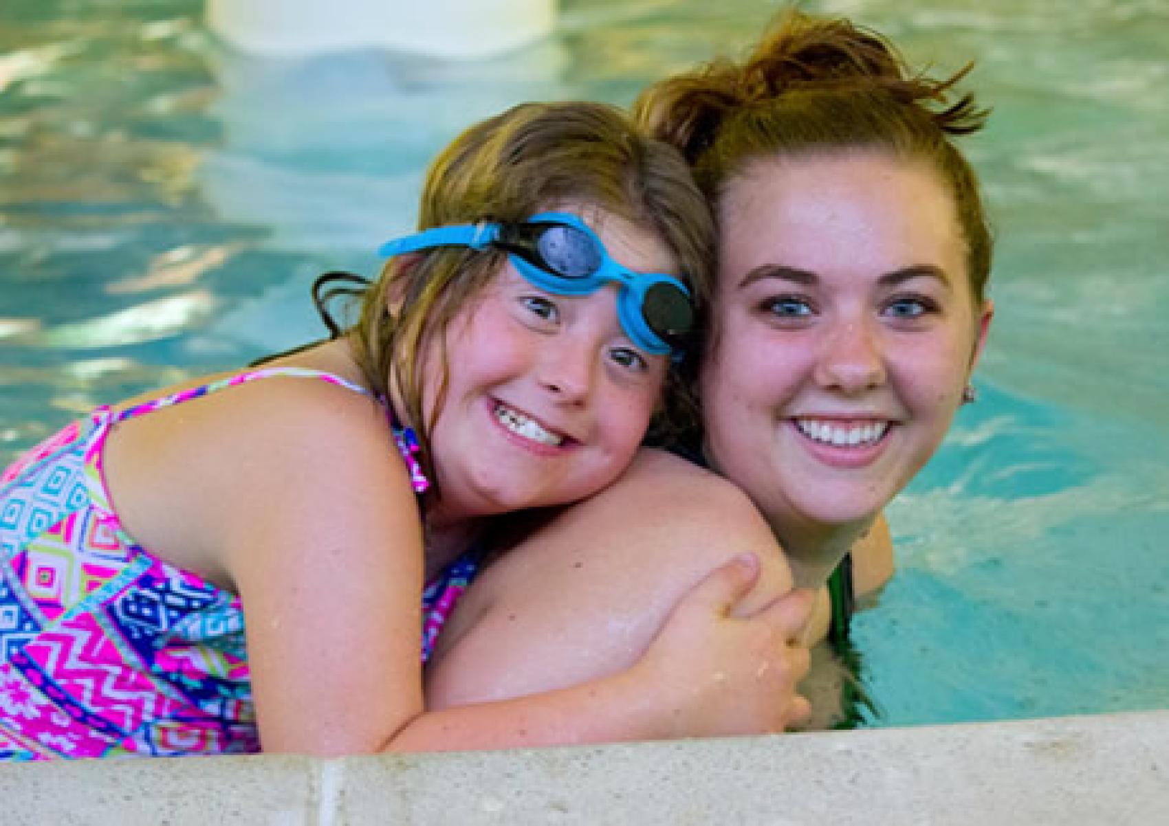 camper and counselor in pool