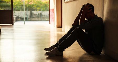 Stressed young person holding hands to head