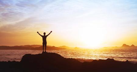 stock photo person watching sunrise over ocean