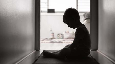 Sad child sitting in hallway