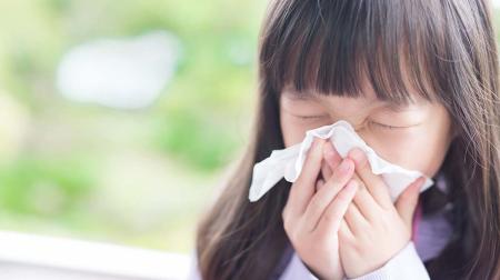 Girl blowing nose with tissue