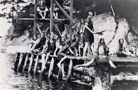 historical photo of campers jumping off a pier at Luther Gulick Camp for Girls in the 1920s