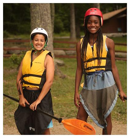 Two campers with life vests and helmets smiling