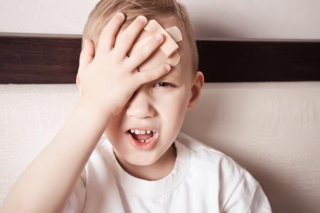 Young boy with bandage on forehead
