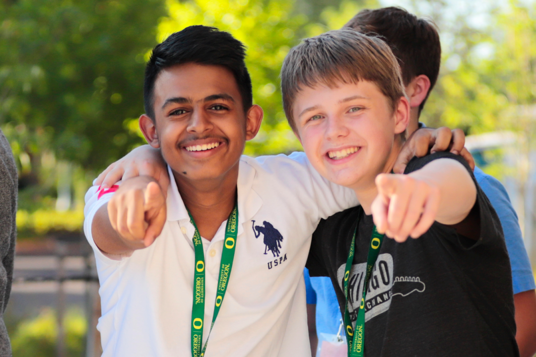 Two campers smiling and pointing at camera