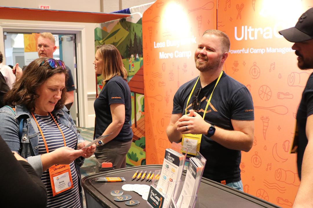 exhibitors talking with attendee