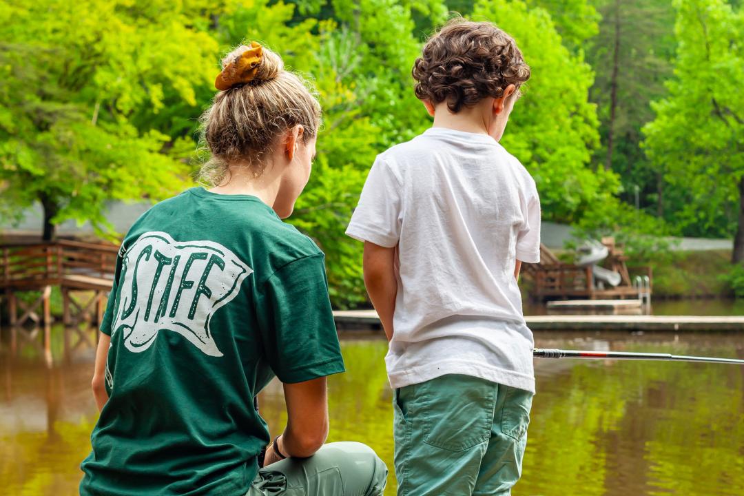 Staff and camper looking at lake