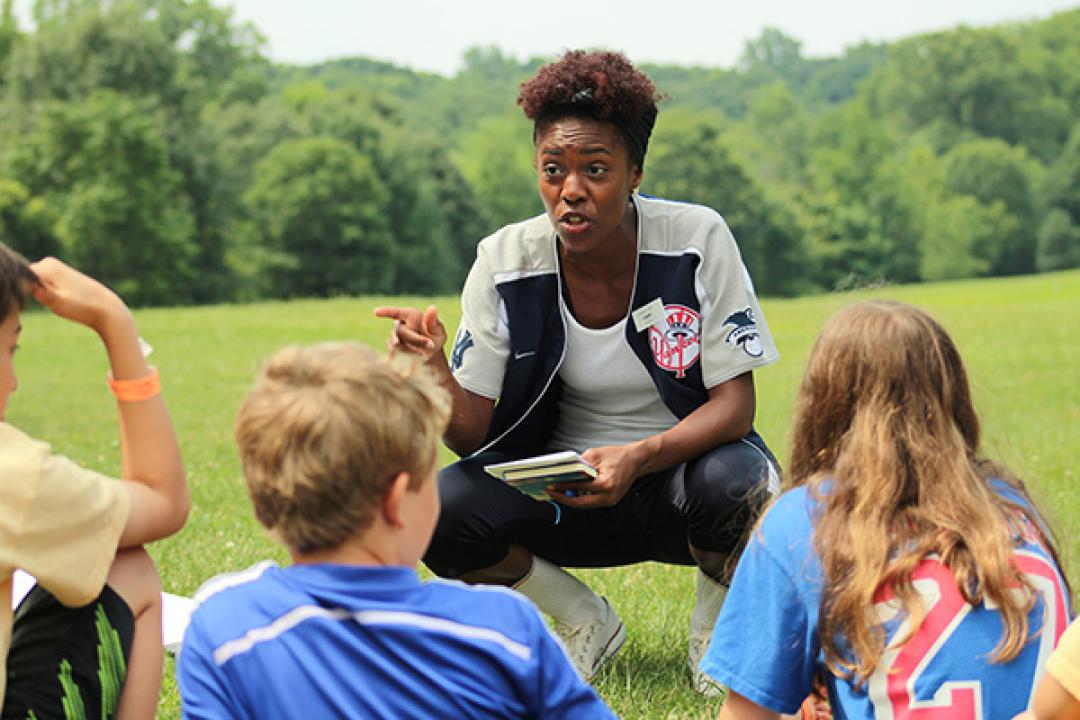 Staff talking to campers on the grass