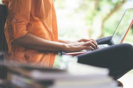 Person typing on laptop outdoors