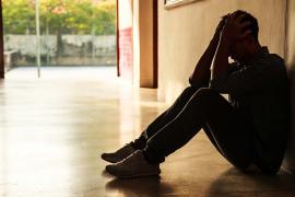 Stressed young person holding hands to head