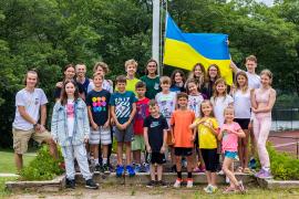 Group of Ukrainian campers standing with Ukrainian flag