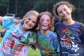 Campers covered in paint smiling for camera