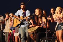 Campers and staff singing and playing music on stage