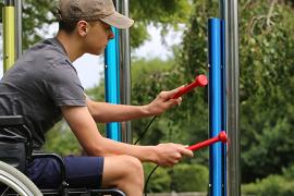 camper in wheelchair playing instrument