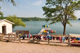 stock photo of lifejackets hanging on fence by lake