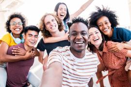 Smiling friends taking group selfie