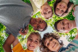 stock photo of kids huddled around camera