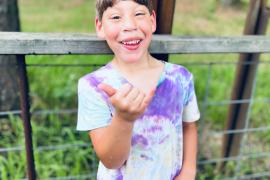 Camper holding up "hang ten" hand