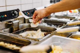 Food getting placed into deep fryer
