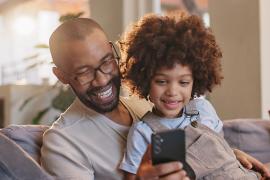 stock photo of parent and child looking at phone