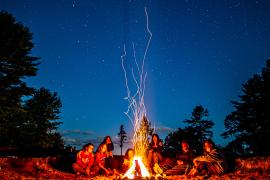 campers sitting around campfire
