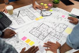 people around table looking at blueprints