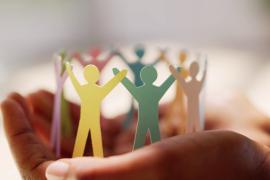 hand holding paper cut out of people