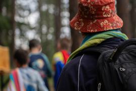 person wearing bucket hat and campers in background