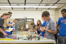 campers painting at an indoor table