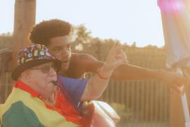 Older camper in a wheelchair pointing at something with a counselor