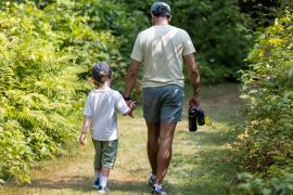 Counselor and Camper walking away in green forest