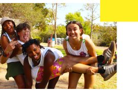 Four counselors laughing while holding each other up