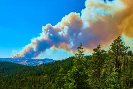 smoke and fire rising from mountain in the distance