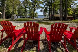 red adirondack chairs with camp in background