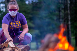 camp staff wearing mask at wood pile