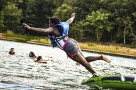 Camper jumping into water