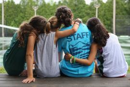 campers with their arms around a camp staff member