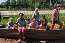 campers posing in a play boat