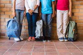 Legs of students against brick wall