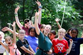 Counselor and campers posing for camera