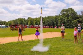 campers in masks launching a rocket