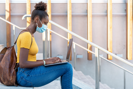 college student wearing mask with laptop